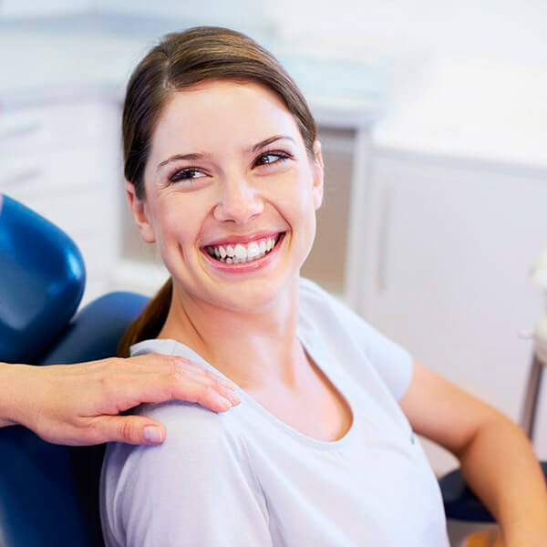 A woman sitting in the dentist chair and smiling