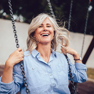 A woman sitting on swing while laughing