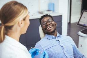 Smiling man in the dental chair, possibly after a root canal